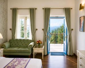 a bedroom with a green couch and a sliding glass door at Pine Retreat - A Premium Heritage Property in Mussoorie +19 photos