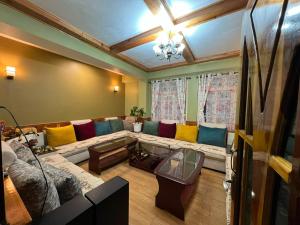 a living room with a couch with colorful pillows at Home away homestay in Namchi