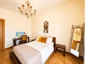 a bedroom with a bed and a mirror and a chandelier at La Casita Del Mar in San Vito lo Capo