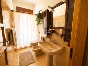 a bathroom with a sink and a toilet and a mirror at La Casita Del Mar in San Vito lo Capo