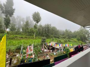 a view of a field with flags on a hill at Home away homestay in Namchi +30 photos