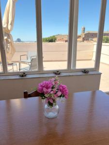 a vase of pink flowers sitting on a table at Casa Manzoni- Appartamento con terrazzo in centro in Mussomeli