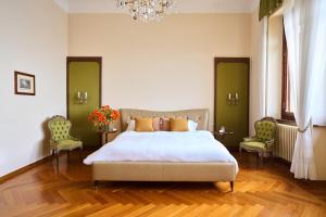 a bedroom with a large bed and two chairs at Villa Jolanda, a Garamonds Property in Brunate