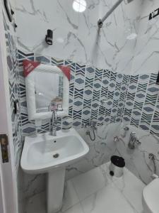 a white bathroom with a sink and a mirror at Ali Guest House in Jazīrat al ‘Awwāmīyah +69 photos