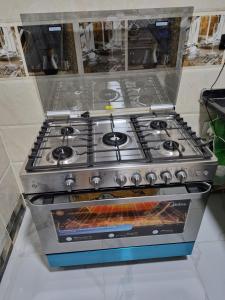 a stove top oven sitting in a kitchen at Ali Guest House in Jazīrat al ‘Awwāmīyah