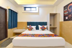 a bedroom with a large bed in a room at FabHotel Metro Residency, Indore Junction Railway Station in Indore