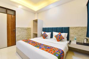 a bedroom with a large bed with colorful pillows at FabHotel Metro Residency, Indore Junction Railway Station in Indore