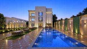 a swimming pool in front of a building at Haldi Kumkum Resort in Limodra