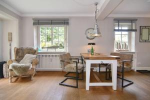 a dining room with a white table and chairs at Gartenweg 9, Whg Oland in Tinnum