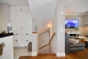 a stairway leading up to a living room with white cabinets at Gartenweg 9, Whg Oland in Tinnum