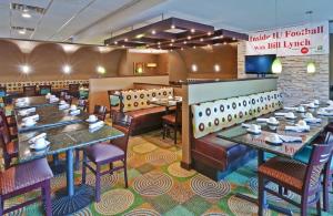 a restaurant with tables and chairs in a room at Holiday Inn Bloomington-University Area by IHG in Bloomington