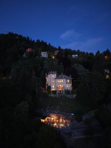 a house sitting on top of a hill at night at Villa Jolanda, a Garamonds Property in Brunate +37 photos