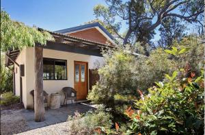 a small house with a chair in front of it at SilverSprings Spa Retreat Pet Friendly Cottages and Glampings in Metricup