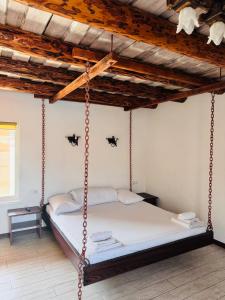a swing bed in a room with a wooden ceiling at Cottage Hata Zustrich in Bukovel