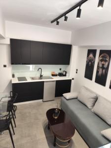 a living room with a couch and a kitchen at Studio Eleni in Plomari