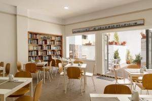 a restaurant with tables and chairs and bookshelves at Sercotel Puerto de Santa María in El Puerto de Santa María +24 photos