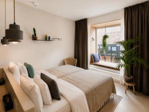 a bedroom with a large bed and a window at Latroupe Hotel Jardin Secret in Brussels