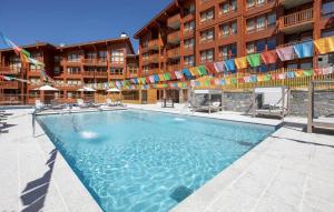 a large swimming pool in front of a building at Hôtel Eden by Odalys in Arc 1800