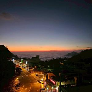 a city street at night with the ocean in the background at Shan Da Ke Qi Min Su in Zhonghe