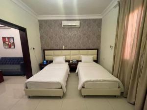 two beds in a hotel room with two beds sidx sidx sidx at فندق قمة البستان الرفاع in Arar