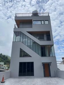 a white building with a balcony on top of it at Shan Da Ke Qi Min Su in Zhonghe