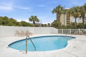 a swimming pool with chairs and a fence at Riviera Dunes 503 in Perdido Key