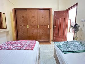 a bedroom with two beds and a wooden door at Spazio Undici 11 in Marsa Matruh