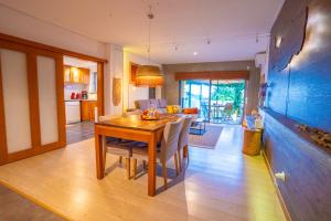 a kitchen and dining room with a wooden table and chairs at epicenter SANTACRUZ in Lagoa