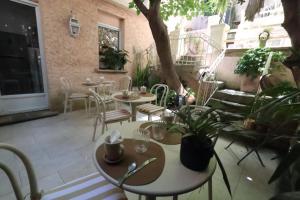 a patio with tables and chairs and a tree at Boutique Hôtel Azur in Marseille