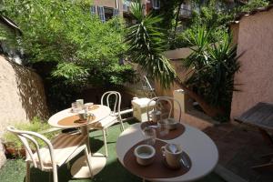 two tables and chairs on a patio with plants at Boutique Hôtel Azur in Marseille
