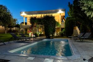 a swimming pool in front of a house at Nataly's Gardens with Pool Lagonissi in Lagonissi