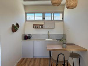 a kitchen with a wooden table and a counter top at בקצה הוואדי - The Wadi Edge in Yeroẖam