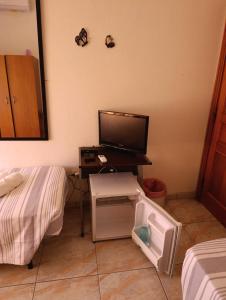 a room with a tv and a desk with a bed at L'Aragosta Guesthouse in Alghero
