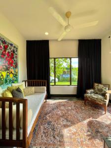a bedroom with a bed and a couch and a window at Rumah Cermin in Langkawi Intl