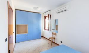 a bedroom with blue cabinets and a chair in it at Villa La Cavaliera in San Vincenzo