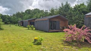 a row of cottages in a field of grass at Reset Camp domki wakacyjne in Siecie