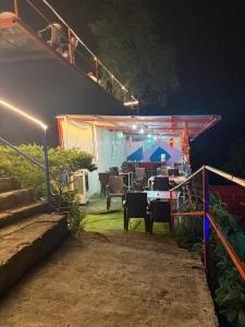 a stage with a table and chairs at night at Shivpuri Ghumakkad Resort in Shivpuri