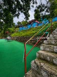 a green field with stairs and a bench on it at Shivpuri Ghumakkad Resort in Shivpuri