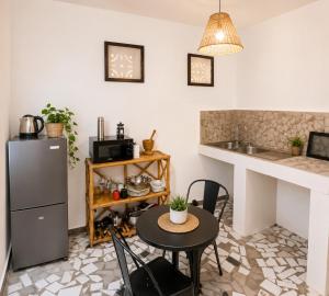 a kitchen with a table and a refrigerator and a counter at Cozy Studio with Private Jacuzzi and Pool! in Saly Portudal
