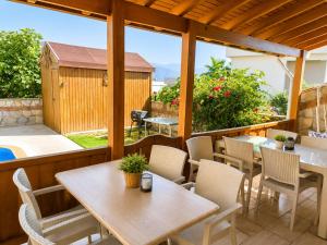 a patio with tables and chairs and a pool at Villa Elma in Kuşadası