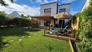 a house with two chairs and an umbrella in the yard at Les flots du bono in Le Bono