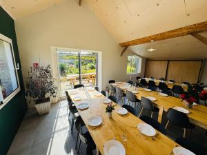 a large room with long tables and chairs at Les Gîtes des Portes de Bretagne in La Chapelle-Saint-Aubert