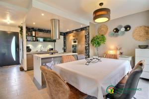 a kitchen and dining room with a white table and chairs at Les flots du bono in Le Bono