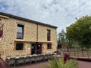 a brick building with chairs in front of it at Le moulin de la hamelle in Yoncq