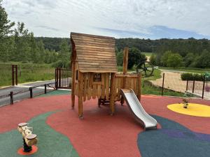 a childrens playground with a slide and a playset at Le moulin de la hamelle in Yoncq