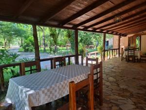 a table on a screened porch with a view of a park at Igli Hotel in Lezhë