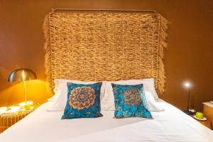 a bed with two pillows and a large headboard at epicenter SANTACRUZ in Lagoa +22 photos