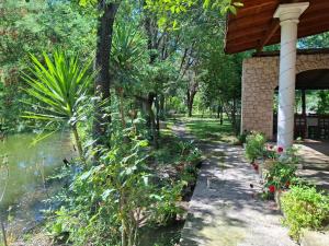 a garden with a walkway next to a building at Igli Hotel in Lezhë