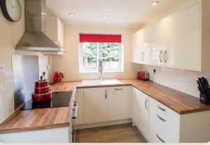 a kitchen with white cabinets and a window at 3 Bed Semi - Sleeps 5 - Private Garden & Parking - Quiet Cul De Sac Location - Dog Friendly - Fast Wifi - Close to Motorway Access in Doncaster +9 photos