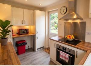a kitchen with a bowl of fruit on the counter at 3 Bed Semi - Sleeps 5 - Private Garden & Parking - Quiet Cul De Sac Location - Dog Friendly - Fast Wifi - Close to Motorway Access in Doncaster